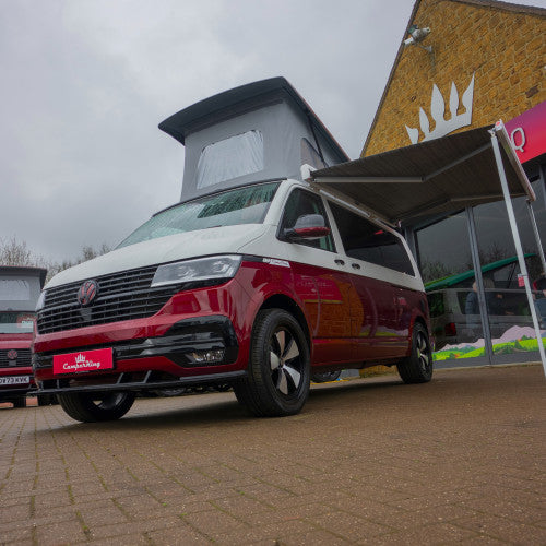 A happy couple taking a photo of themselves outside their well protected campervan.