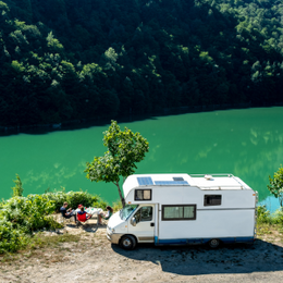A woman sitting outside her motorhome watching the sunset able to enjoy the peace of mind that comes with Moving Intelligence’s highly rated service and insurance accredited devices specifically designed for motorhomes.