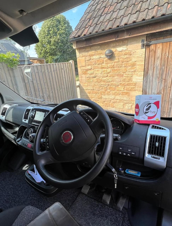 The cab of a Fiat motorhome with a Moving Intelligence card on the dashboard.