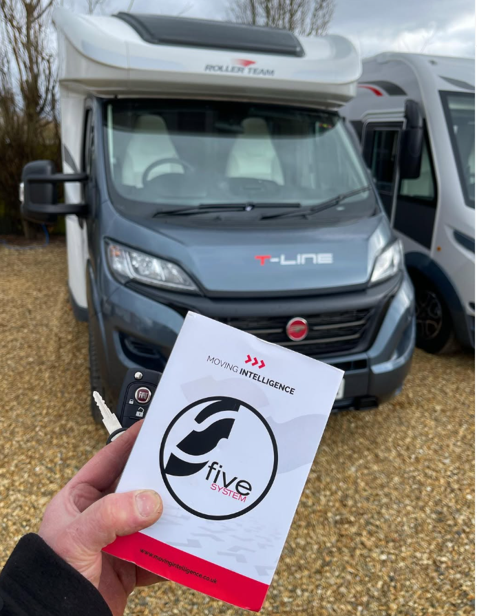An S5 booklet held in front of a Roller Team X-Line motorhome.