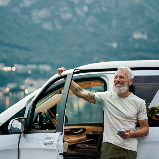 A couple outside their caravan with their dog watching the sunset protected by Moving Intelligence's specially designed GPS tracking devices with insurance accreditation.
