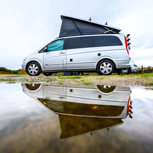 A woman sitting outside her motorhome watching the sunset able to enjoy the peace of mind that comes with Moving Intelligence's highly rated service and insurance accredited devices specifically designed for motorhomes.