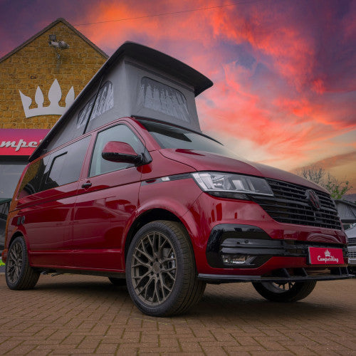 A woman sitting outside her campervan watching the sunset able to enjoy the peace of mind that comes with Moving Intelligence's highly rated service and insurance accredited devices specifically designed for motorhomes.