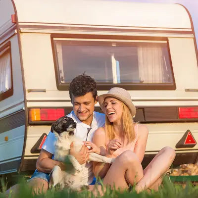 A woman looking at the sea besides her safe and secure caravan.