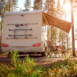 A woman looking at the sea besides her safe and secure caravan.