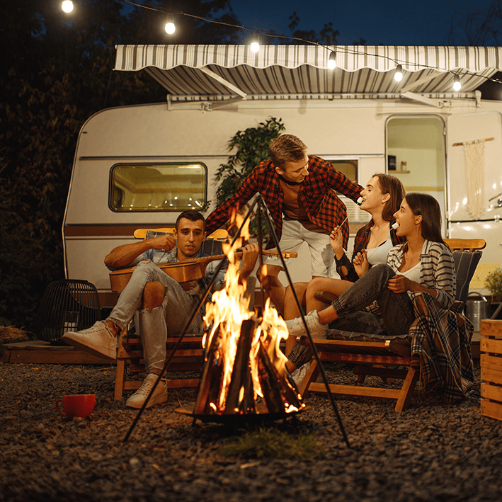 A happy group around a campfire outside their secure caravan enjoying peace of mind.
