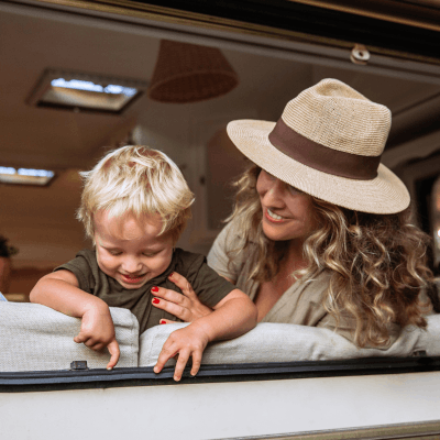 Mother and child happily sat inside of their caravan looking out the window with pet mode turned on, which means the outside is protected.