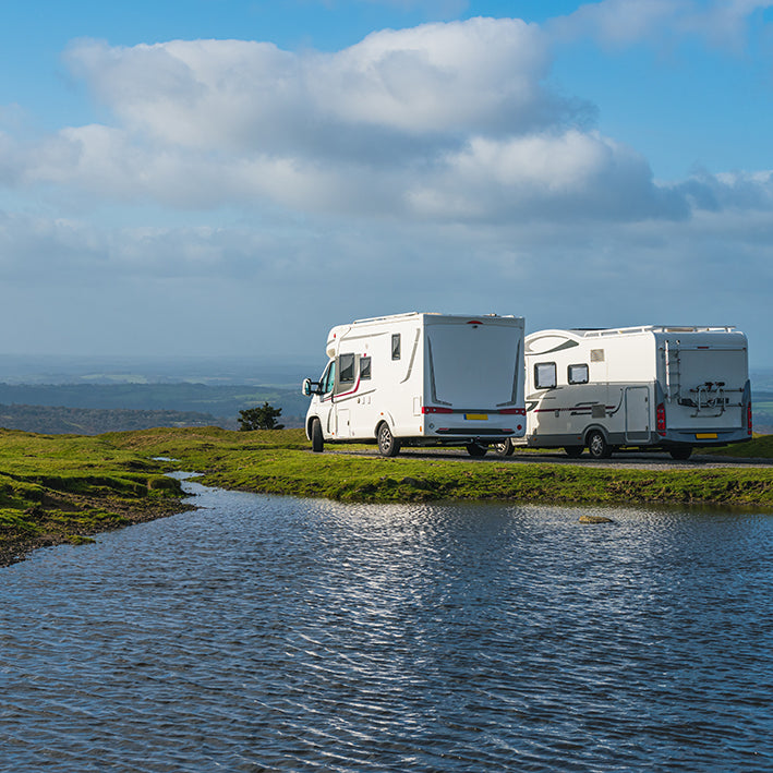 Two motorhomes protected by Moving Intelligence with leading GPS and GSM tracking overlooking the horizon beside a beautiful lake.