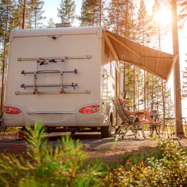 A woman sitting outside her motorhome watching the sunset able to enjoy the peace of mind that comes with Moving Intelligence’s highly rated service and insurance accredited devices specifically designed for motorhomes.